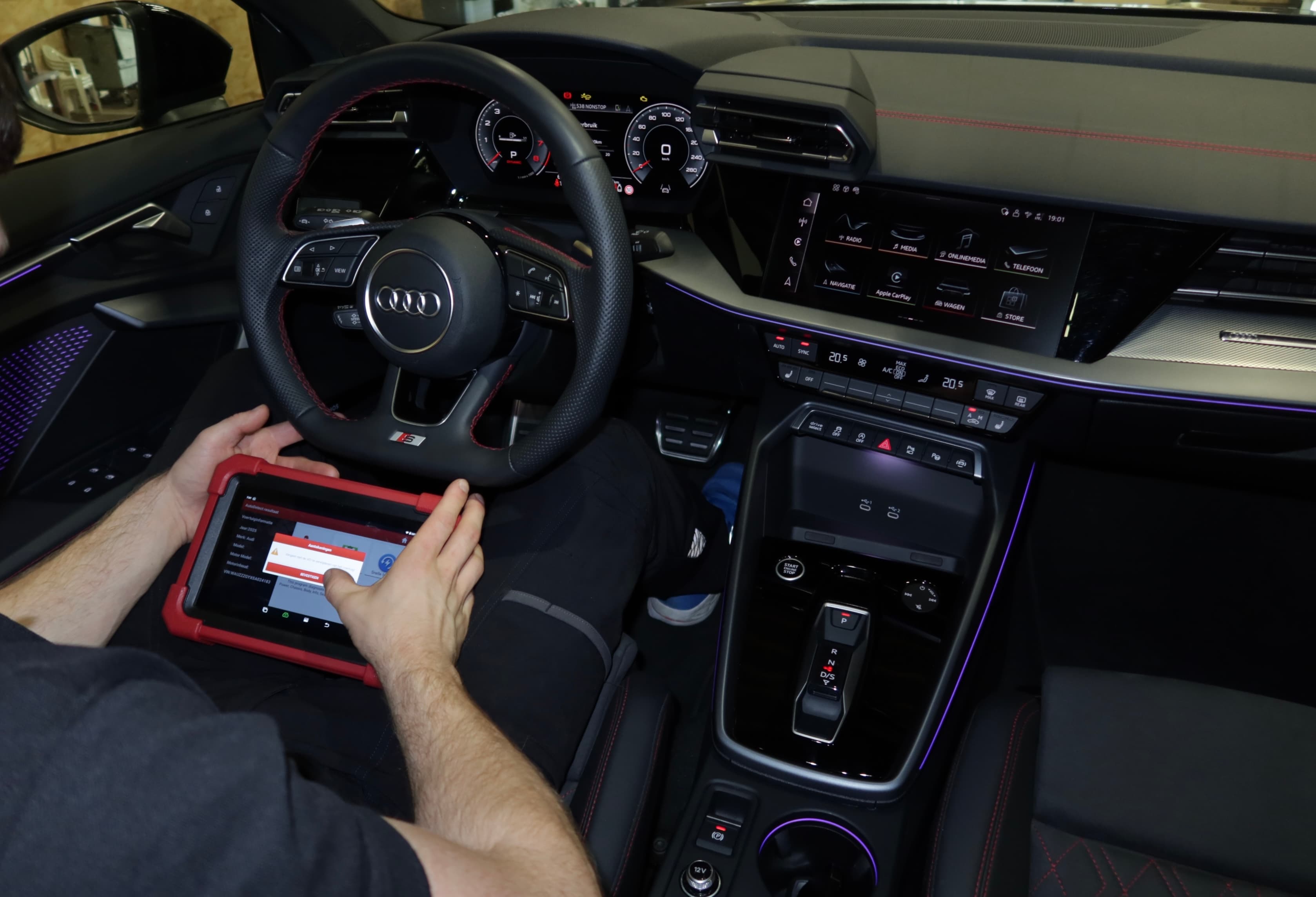 Een Audi wordt uitgelezen in de werkplaats